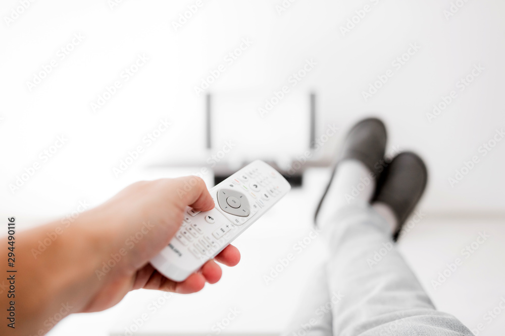Man looking at TV with legs on the table in living room. Man looking at TV with legs on the table in living room.