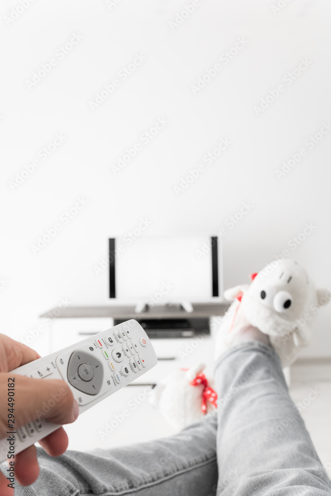 Woman looking at TV with legs on the table in living room. Woman looking at TV with legs on the table in living room.
