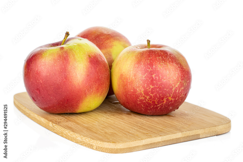 Group of three whole red apple jonagold on bamboo cutting board isolated on white background Group of three whole red apple jonagold on bamboo cutting board isolated on white background