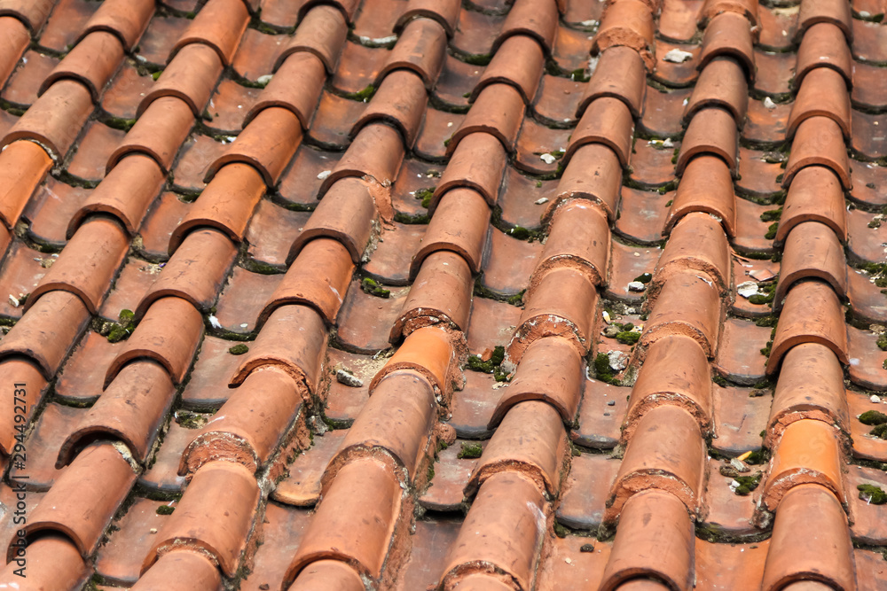 Partially damaged roof tiled with imbrices and tegulae. Photo in perspective with selective focus Partially damaged roof tiled with imbrices and tegulae. Photo in perspective with selective focus
