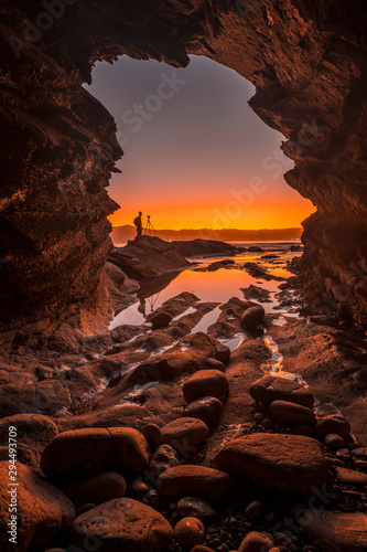 Photographing from a cave the silhouette of a photographer in a sunset © unai