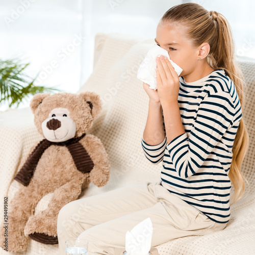 diseased kid sneezing in tissue neat teddy bear