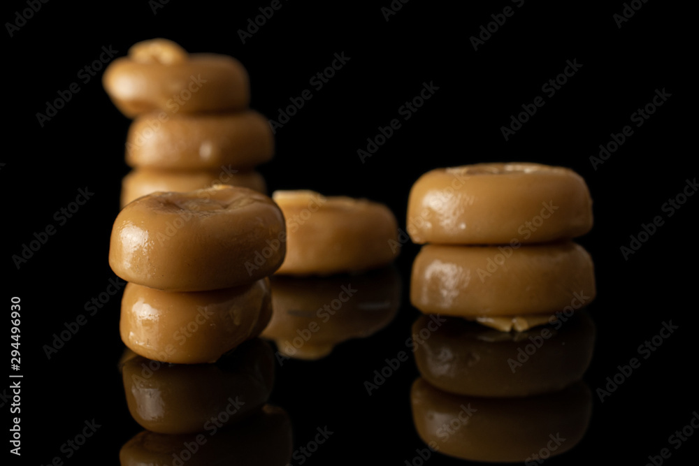Lot of whole arranged caramel brown candy heap isolated on black glass Lot of whole arranged caramel brown candy heap isolated on black glass