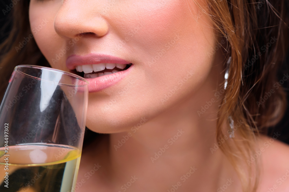 Close-up of young elegant woman drinking champagne against black background. Close-up of young elegant woman drinking champagne against black background.