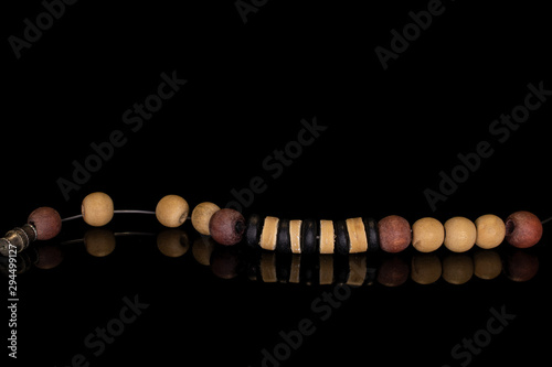 Lot of whole wooden bead isolated on black glass