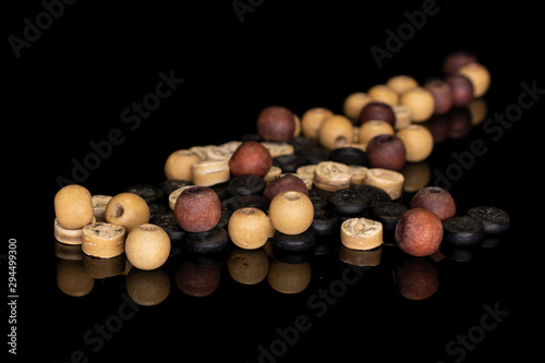 Lot of whole wooden bead heap isolated on black glass