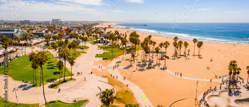 Fototapeta Naklejka Na Ścianę i Meble -  Aerial view of the Venice Beach district, in LA, California, near the artist Rip Cronk. A view of the beach, tennis courts, muscle gym, palm trees and the  main broadway.