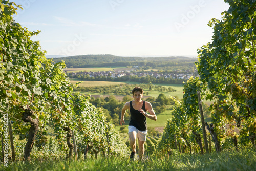 dynamic running jogger Runner jogging  young attractive shorts between vineyards sportsman sunset greenery nature sprint uphill  