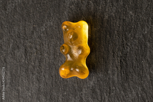 One whole gummy bear flatlay on grey stone