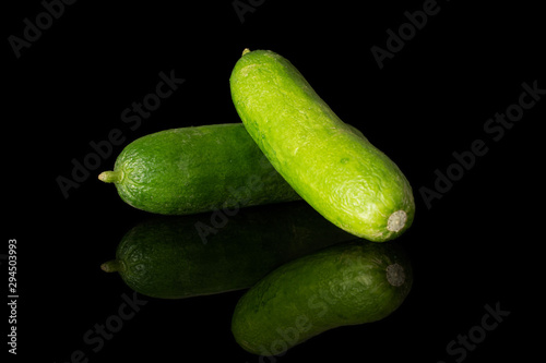 Group of two whole mini green cucumber isolated on black glass