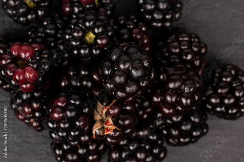 Lot of whole fresh black blackberry flatlay on grey stone photo