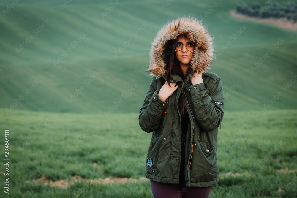 Portrait of a woman feeling cold in winter on green meadow