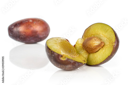 Group of one whole two halves of sweet purple plum isolated on white background