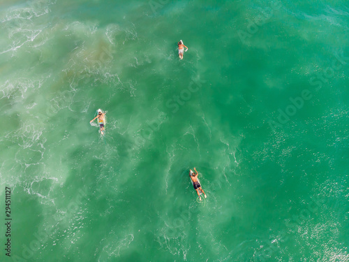 A view from above of the surfers in the ocean