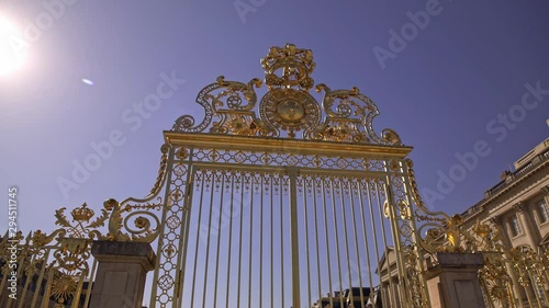 Pan shot of golden gate to the Palace of Versailles in France on background of blue sky without clouds photo