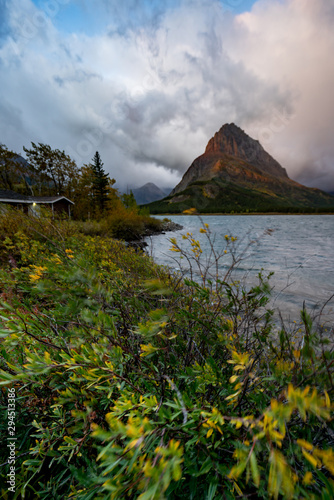 The sunrise lighting up the mountains in the background of Swiftcurrent Lake, Montana.