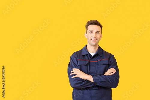 Male car mechanic on color background