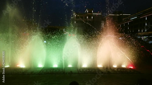 Amazing red and yellow lights and sound show in the fountains in the central town square at dusk in Xian, China photo