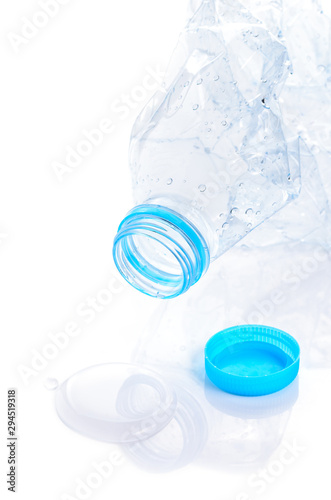 crumpled PET plastic bottle of drinking water on white background, waste plastic bottle to be recycled, recyclable waste concept, image with copyspace