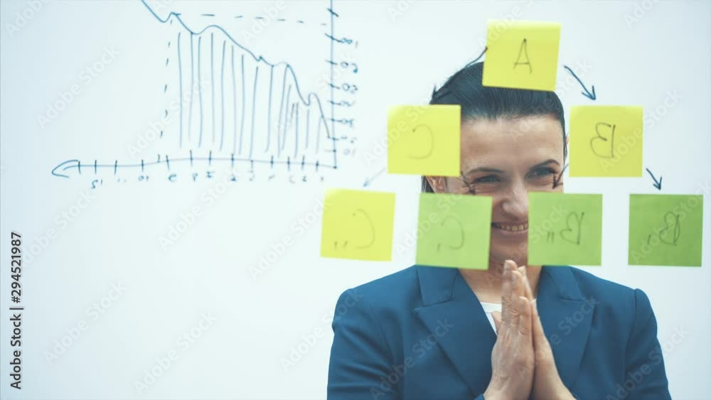 The business lady picks up different growth charts, calculates the prospect of success on glass. The teacher is drawing a task. Close-up The business lady picks up different growth charts, calculates the prospect of success on glass. The teacher is drawing a task. Close-up