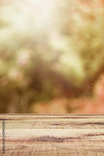 Wooden table and blurred bokeh autumn background.