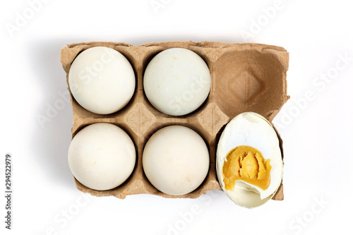 Salted duck's egg on white background with one of it being cut half photo