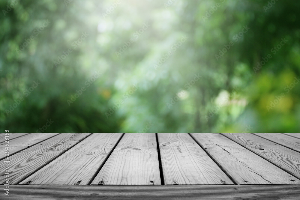 Blurred abstract green bokeh of garden and wooden table background. Blurred abstract green bokeh of garden and wooden table background.