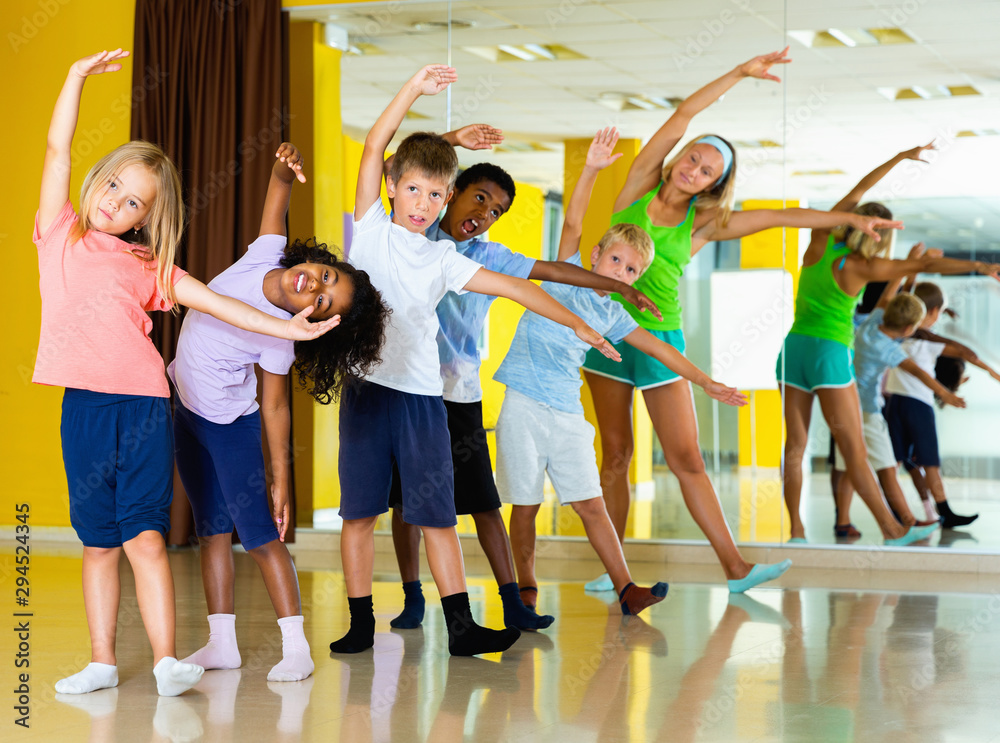 Preteen dancers practicing dance routine with female choreograph
