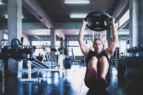 Young handsome man doing exercises in gym.