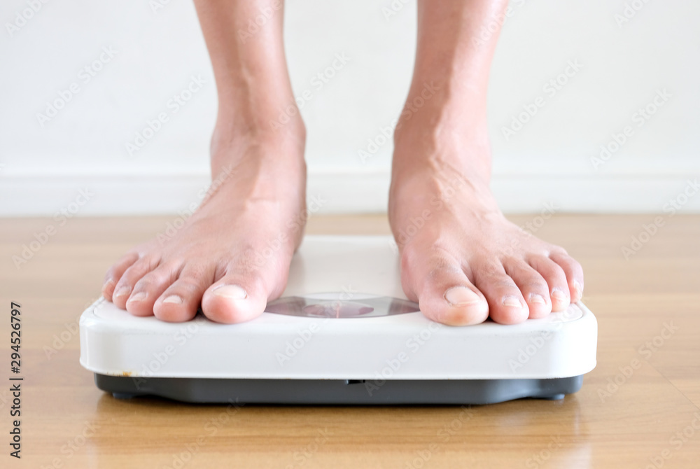 Fototapeta premium Legs of women standing on scales weight background fitness room. Concept of healthy lifestyle and sport