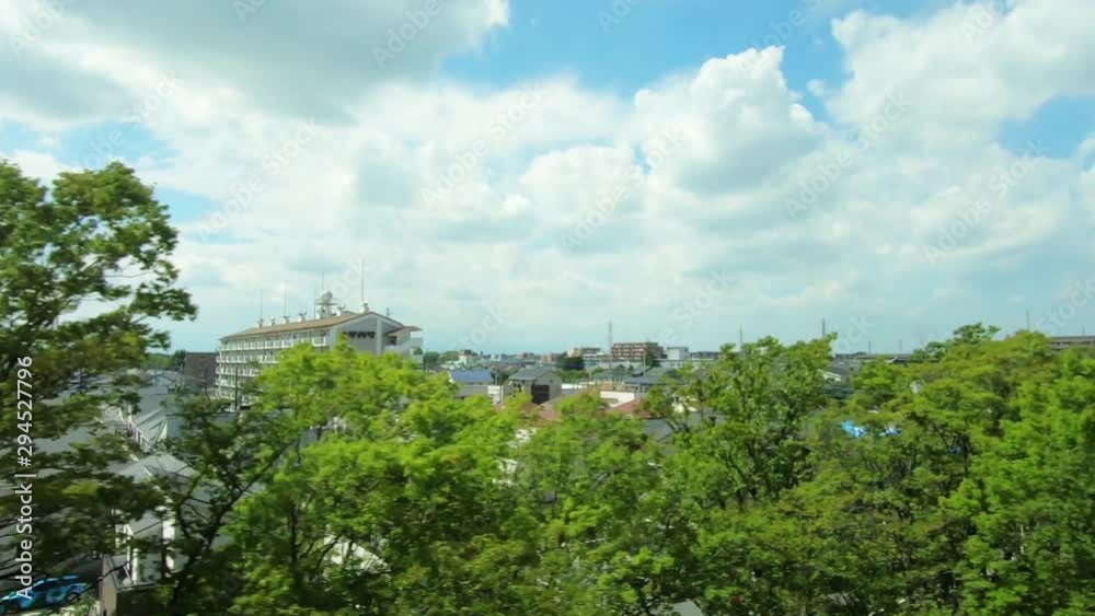 Japan Railway train window. View of residential area with sky, clouds