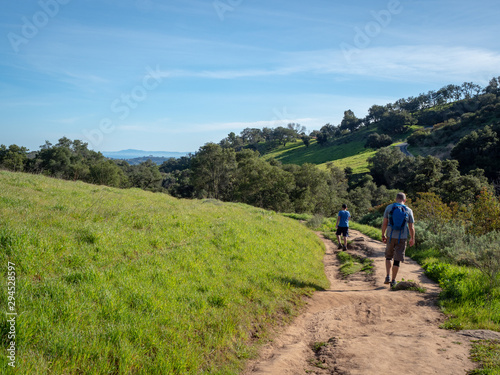 Father and son hiking on Jesusita Trail with panoramic view of ocean and Channel Islands, Santa Barbara, California, USA