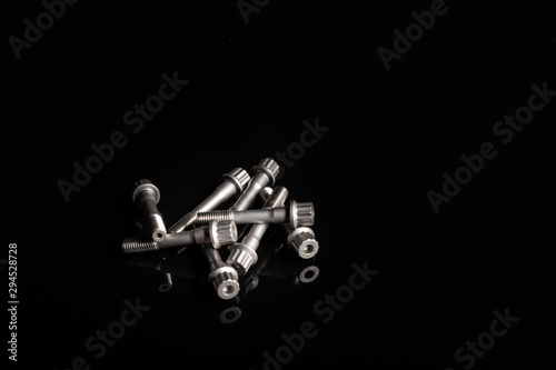 con rod bolts on a black reflective background