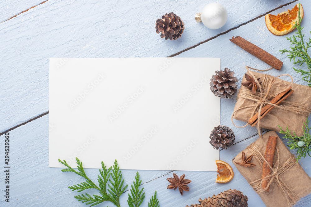Flat lay Christmas composition with a white card for design with Christmas tree branches, Christmas toys, and space for design Flat lay Christmas composition with a white card for design with Christmas tree branches, Christmas toys, and space for design