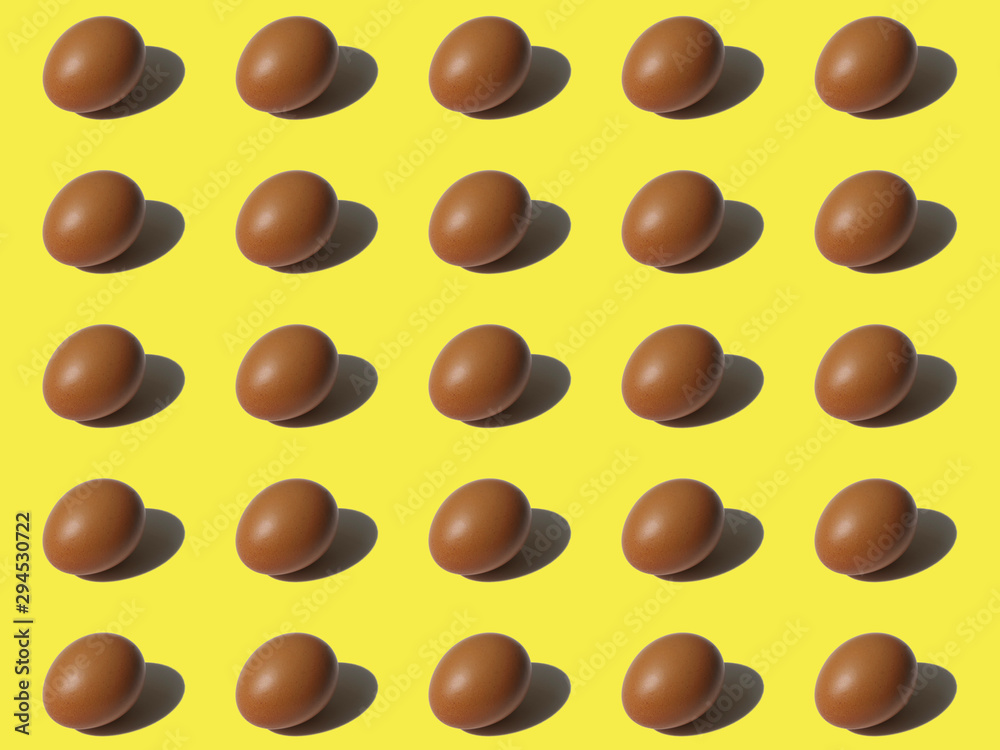 Pattern of brown chicken egg with reflection on yellow background. Minimal food fashion concept. Pattern of brown chicken egg with reflection on yellow background. Minimal food fashion concept.