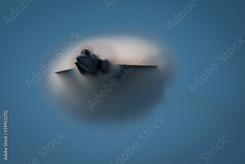 Jet breaks through vapor cone, flying at speed photo
