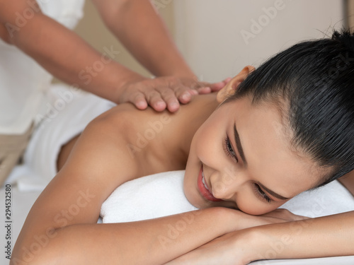 Asian woman relaxing and smile on bed mattresses In the Spa. Thai massage for health.