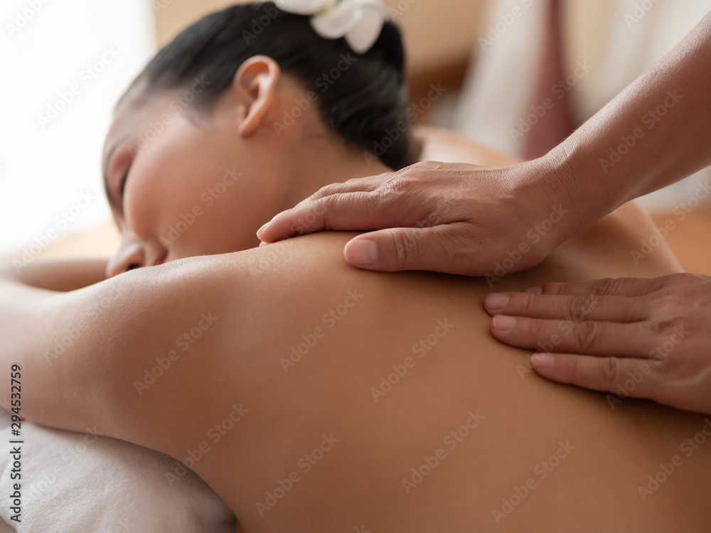 Hand of masseuse's on the backs of women. Asian woman are a relaxing on the bed. Massage and body care. Spa in salon Hand of masseuse's on the backs of women. Asian woman are a relaxing on the bed. Massage and body care. Spa in salon