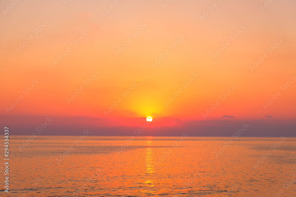 Damatic sunset on sea wit sun reflection on water