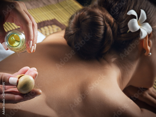 oil massage fragment of young beautiful woman in spa environment.   photo