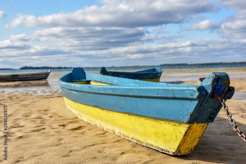 Wooden boats on drying lake as a concept of ecological catastrophy. Natural disaster as a result of human interference in nature.