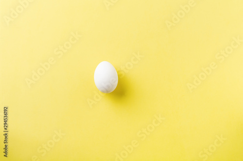 White raw chicken eggs lying on light concrete background. Top view.