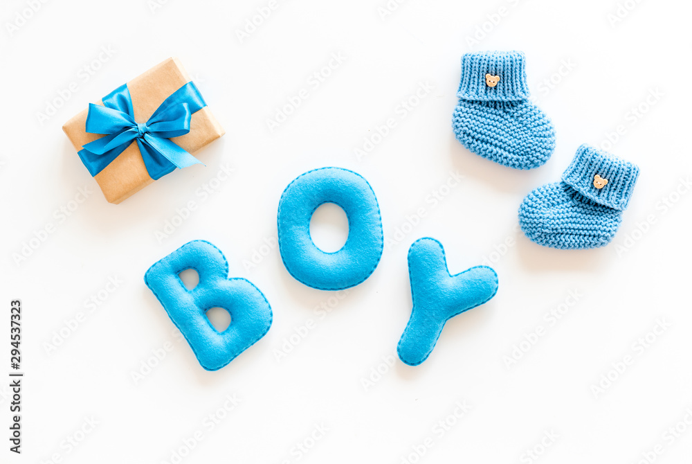 Naklejka premium Children's birthday concept. Word boy near booties and present box on white background top view