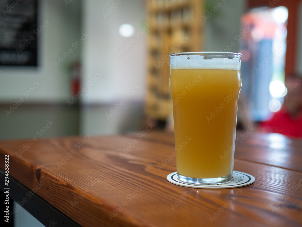 Full freshly poured glass of beer with foam on head on restaurant table Full freshly poured glass of beer with foam on head on restaurant table