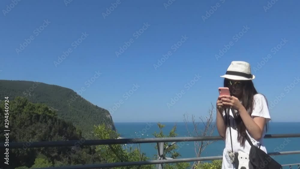 A tourist girl on phone and sea behind A tourist girl on phone and sea behind