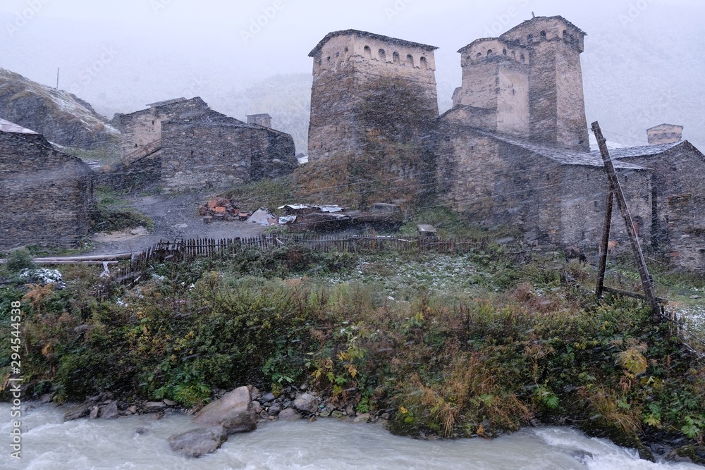 View of the Ushguli village with characteristic stone towers at the foot of Mt. Shkhara in Caucasus Mountains in a slightly winter scenery. Svaneti, Georgia. It is on UNESCO World Heritage Site.