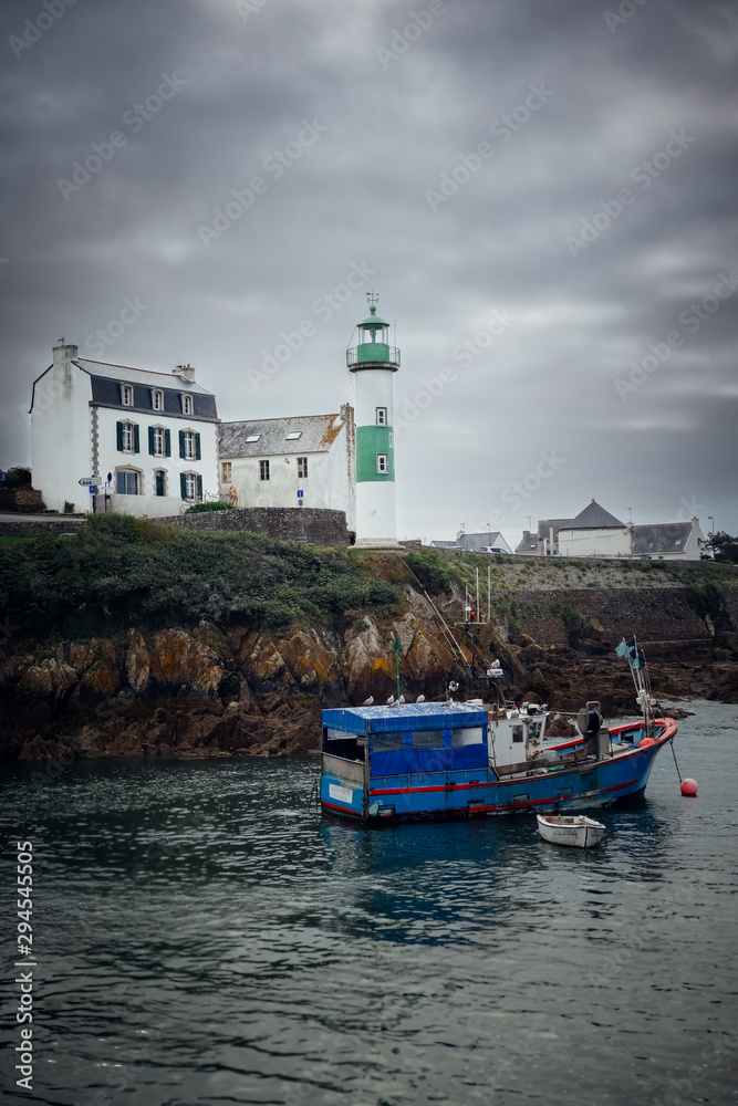 bateau de pêche devant un phare en Bretagne