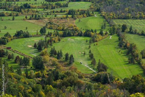 Golf course seen from above during autumn  with pine trees and other trees turning red and orange. Quebec  Canada