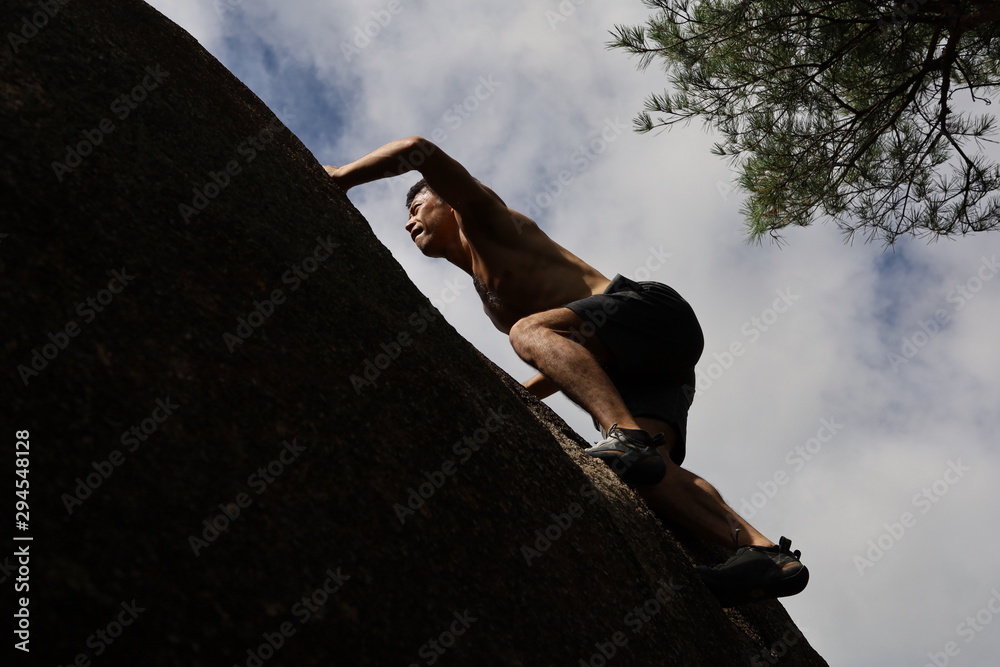 ボルダリングする日本人男性 StockFoto Adobe Stock