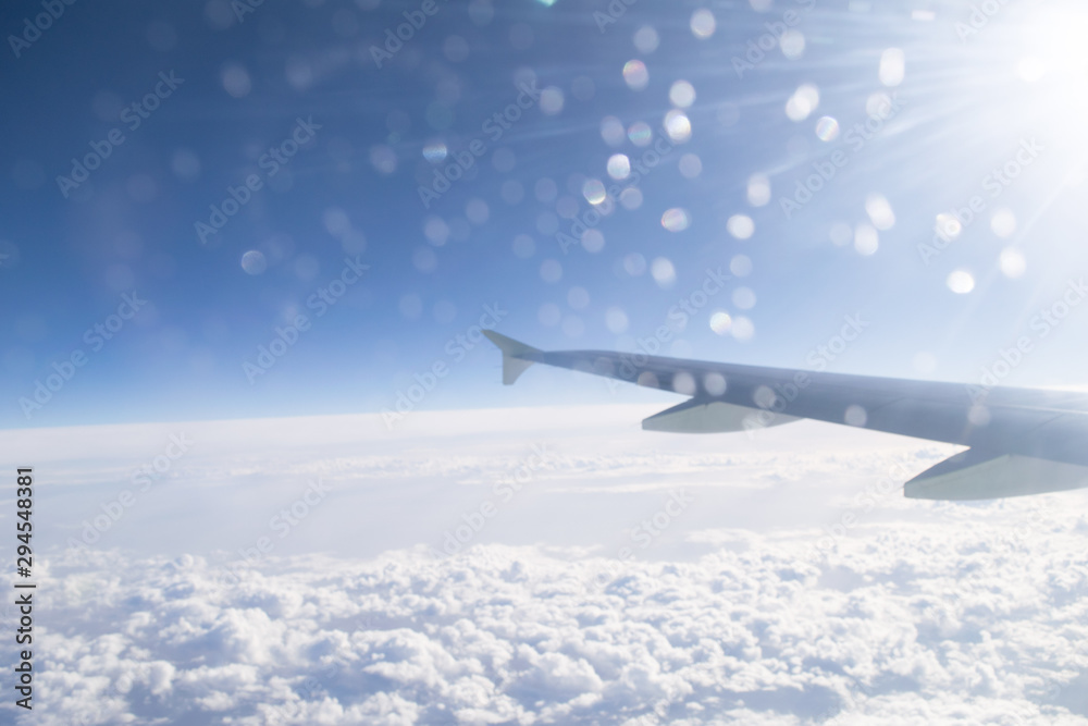 Fototapeta premium High in the sky landscape with clouds and airplane wing, view from the airplane window